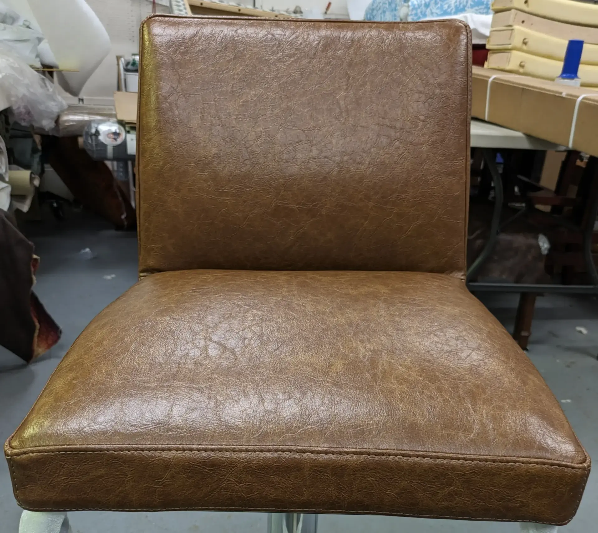 Upholstered chair showing brown leather upholstery