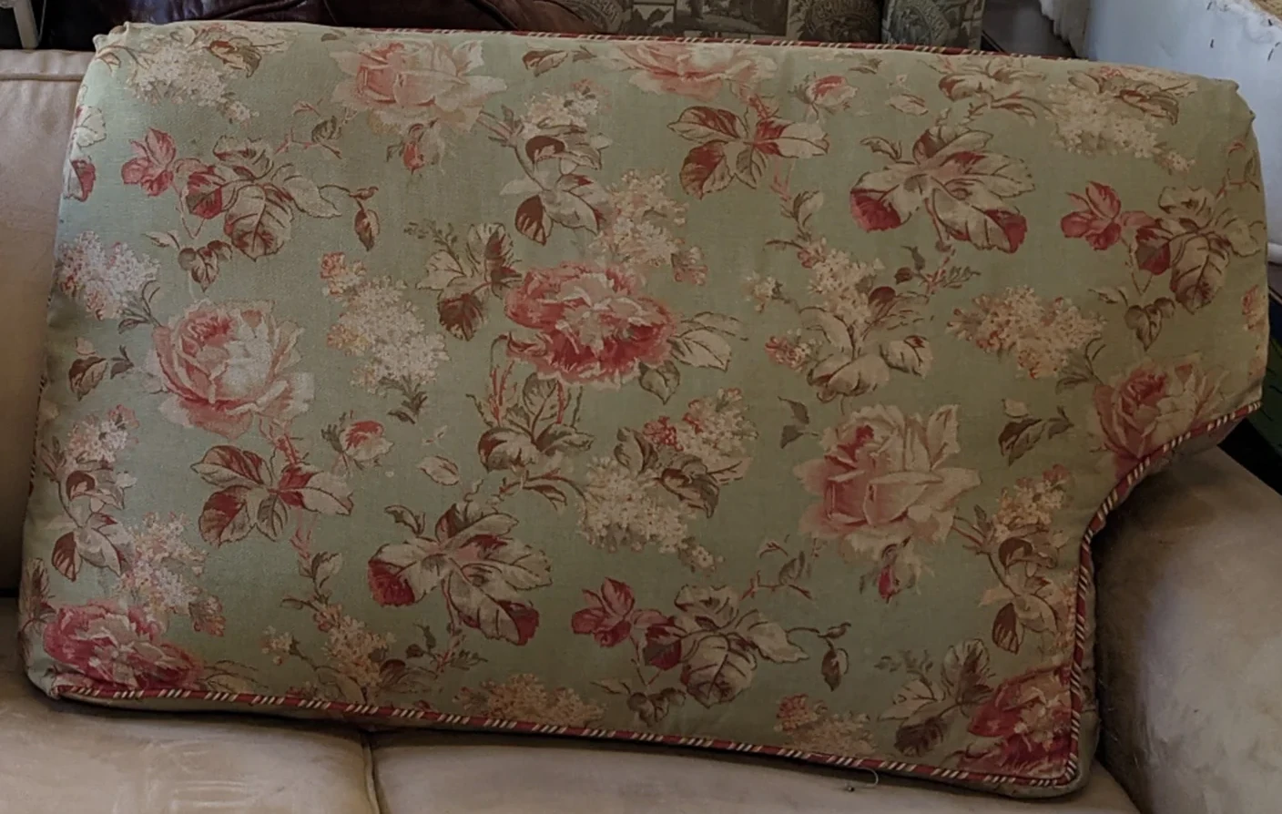 Large floral upholstered cushion resting on a sofa