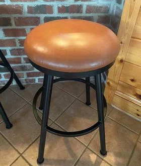 Same round bar stool after reupholstery in brown leather