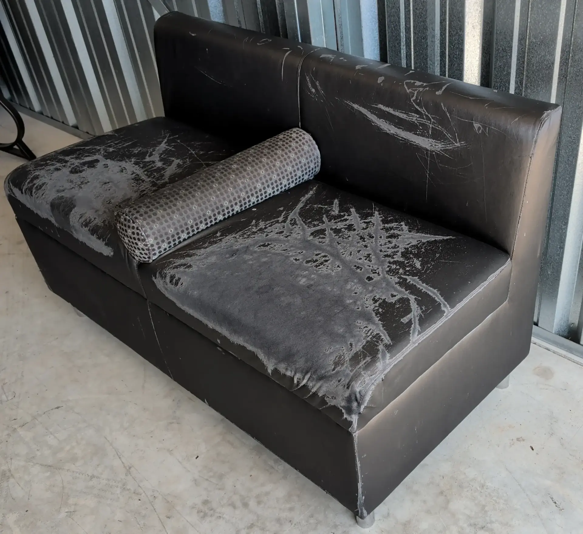 Heavily worn upholstered commercial seating showing extensive surface damage